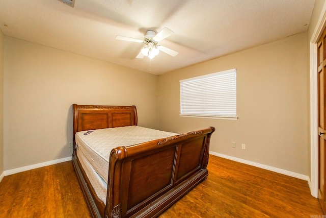 bedroom with a textured ceiling, dark hardwood / wood-style flooring, and ceiling fan