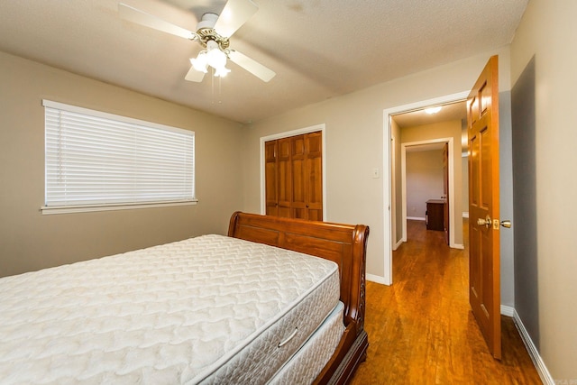 bedroom featuring a textured ceiling, a closet, hardwood / wood-style flooring, and ceiling fan