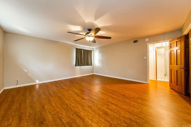 empty room featuring wood-type flooring, a textured ceiling, and ceiling fan