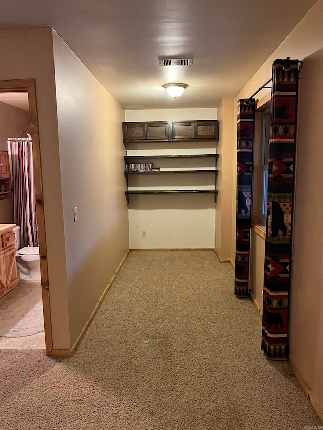 corridor featuring light colored carpet