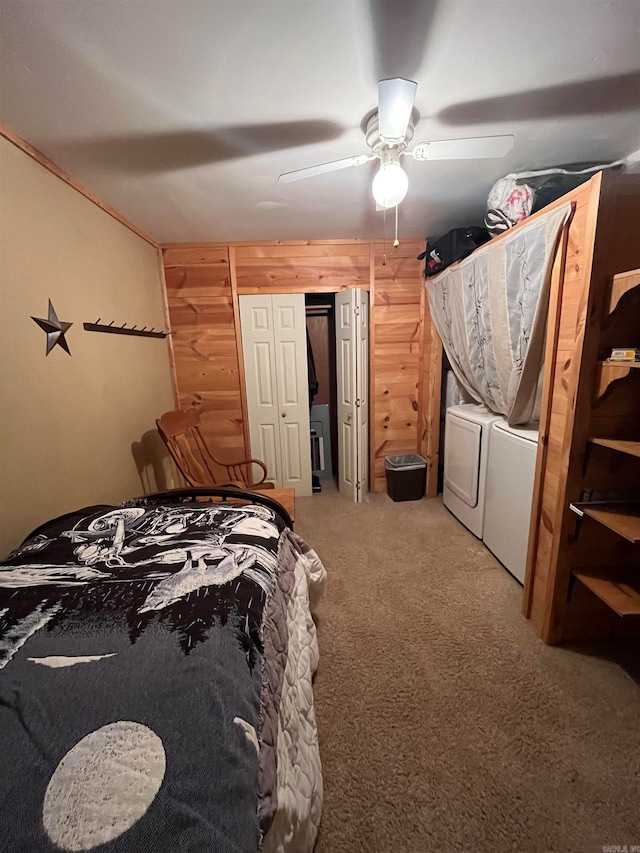 bedroom featuring carpet flooring, ceiling fan, wooden walls, and washer and clothes dryer