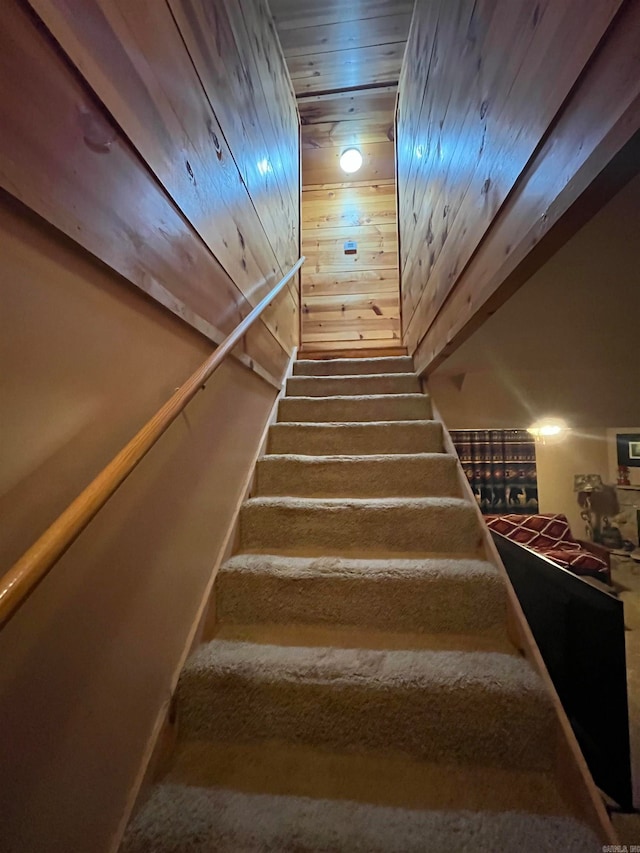 staircase with carpet floors and wooden ceiling