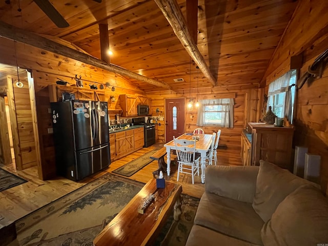 kitchen featuring wood ceiling, stainless steel appliances, hardwood / wood-style flooring, vaulted ceiling with beams, and wood walls