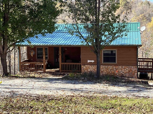 1217 Lovell Ln, Mountain View, AR 72560 - rustic home featuring stone siding, a porch, and metal roof