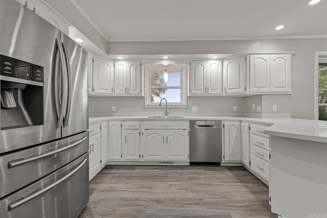 kitchen with white cabinets, sink, stainless steel appliances, and a wealth of natural light