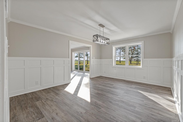 unfurnished dining area with ornamental molding and hardwood / wood-style flooring