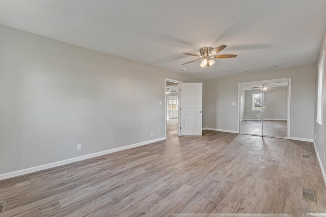 unfurnished bedroom featuring light wood-type flooring, a closet, and ceiling fan