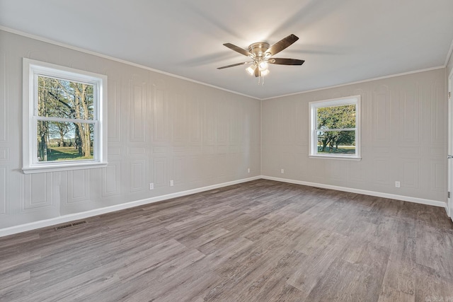 unfurnished room featuring ceiling fan, light hardwood / wood-style flooring, a healthy amount of sunlight, and ornamental molding