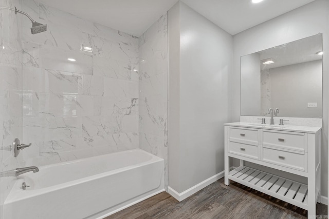 bathroom featuring tiled shower / bath combo, wood-type flooring, and vanity