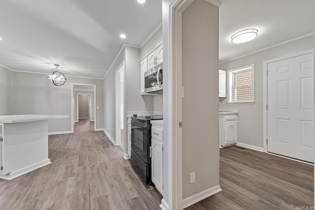 kitchen featuring white cabinets, light wood-type flooring, crown molding, and black range with electric cooktop