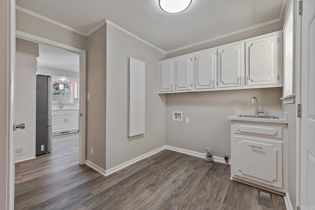 clothes washing area with sink, cabinets, dark hardwood / wood-style flooring, crown molding, and hookup for a washing machine