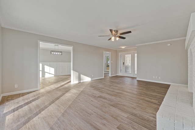 unfurnished living room featuring ceiling fan with notable chandelier, wood-type flooring, and crown molding