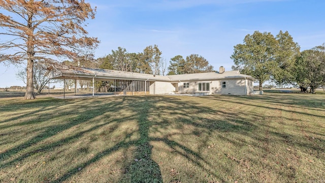 rear view of property with a lawn