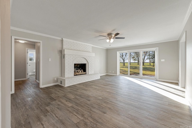 unfurnished living room with crown molding, a brick fireplace, ceiling fan, a textured ceiling, and dark hardwood / wood-style flooring