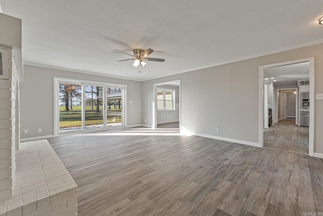 unfurnished living room featuring ceiling fan, ornamental molding, a textured ceiling, and hardwood / wood-style flooring