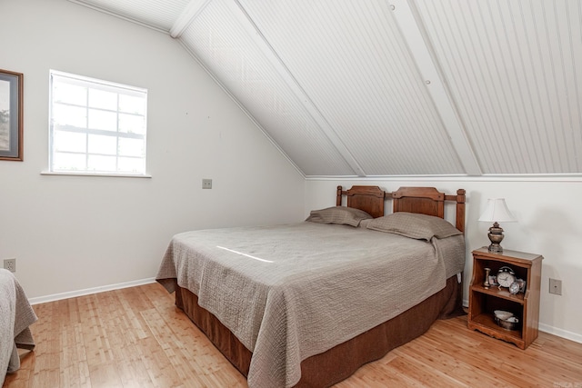 bedroom with light hardwood / wood-style floors and lofted ceiling