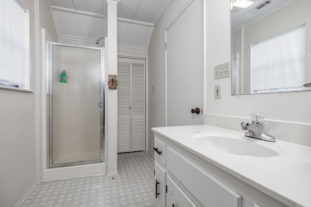 bathroom featuring vanity, ornamental molding, and walk in shower