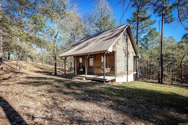 exterior space featuring covered porch and a front yard