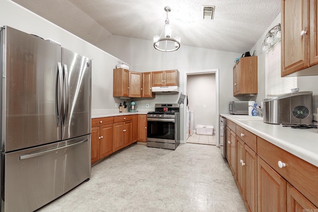 kitchen with an inviting chandelier, vaulted ceiling, a textured ceiling, decorative light fixtures, and stainless steel appliances