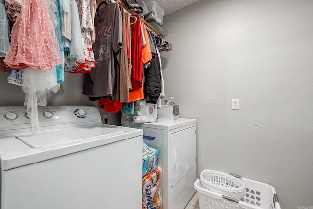 laundry room with separate washer and dryer, light tile patterned flooring, and a textured ceiling