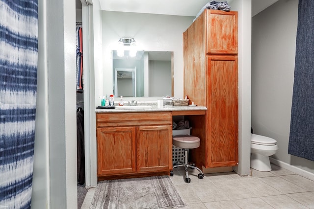 bathroom with tile patterned flooring, vanity, and toilet