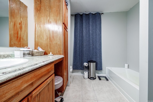 bathroom with tile patterned flooring, a bath, vanity, and toilet