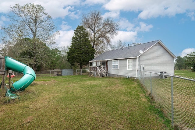 back of house featuring a playground, central AC unit, and a lawn