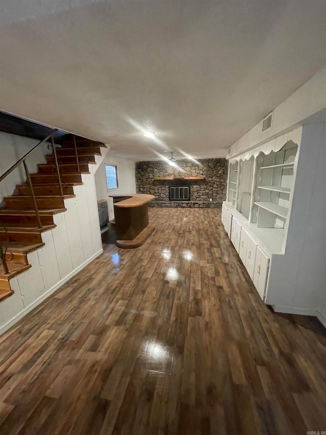 unfurnished living room with a fireplace and dark wood-type flooring