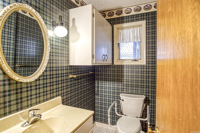 bathroom featuring vanity, a textured ceiling, toilet, and tile patterned flooring