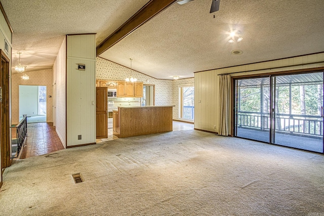 unfurnished living room with lofted ceiling with beams, a textured ceiling, light colored carpet, and ceiling fan