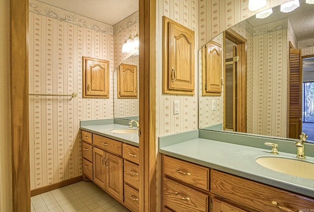 bathroom featuring tile patterned flooring, vanity, and a textured ceiling