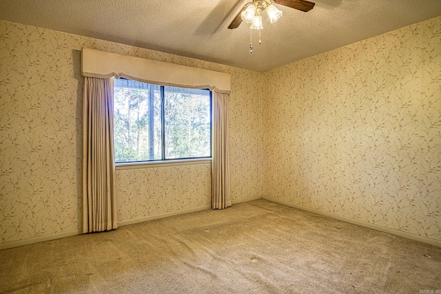 carpeted empty room with ceiling fan and a textured ceiling