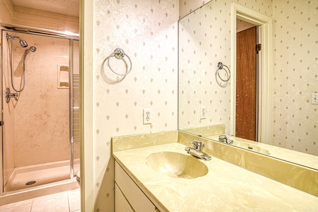 bathroom featuring tile patterned flooring, vanity, a textured ceiling, and walk in shower