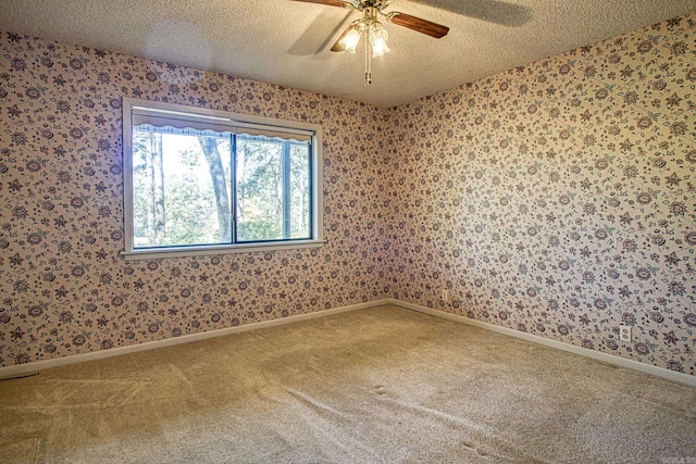 carpeted empty room with ceiling fan and a textured ceiling