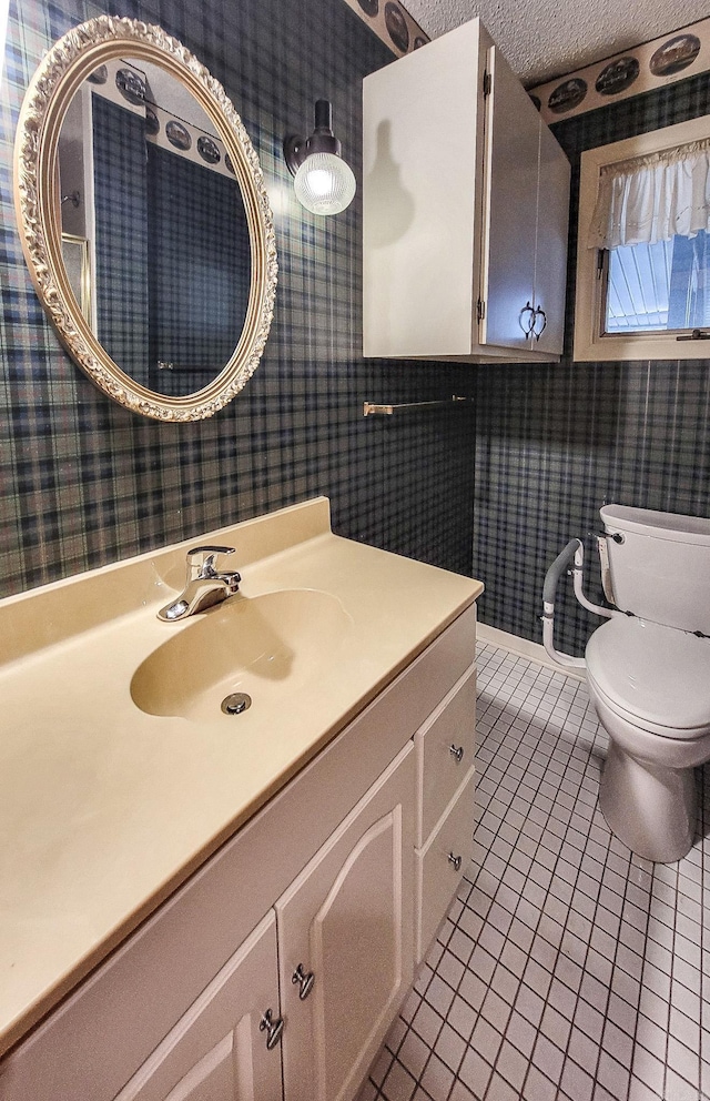 bathroom featuring tile patterned floors, vanity, toilet, and a textured ceiling