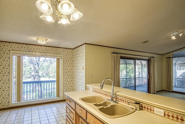 kitchen featuring pendant lighting, an inviting chandelier, sink, light tile patterned floors, and a textured ceiling