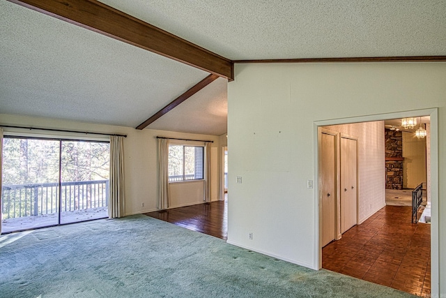 empty room featuring lofted ceiling with beams, a textured ceiling, and dark colored carpet