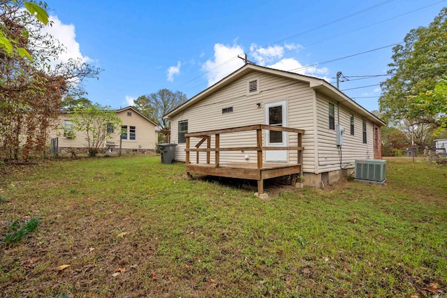 rear view of property with a yard, a deck, and central AC unit