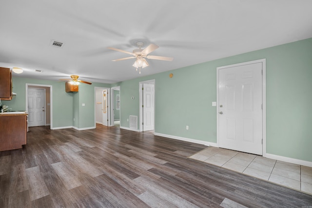 unfurnished living room with ceiling fan and wood-type flooring