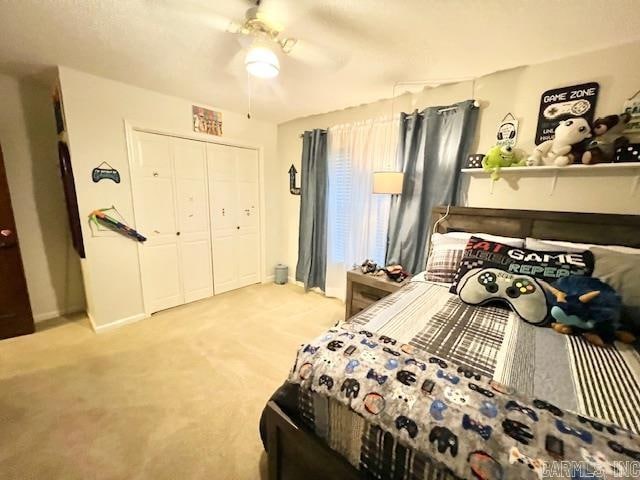 bedroom with ceiling fan, a closet, and light colored carpet