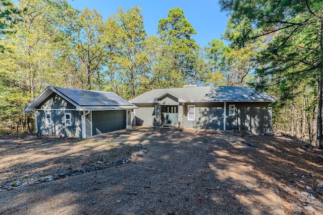 ranch-style home featuring solar panels and a garage