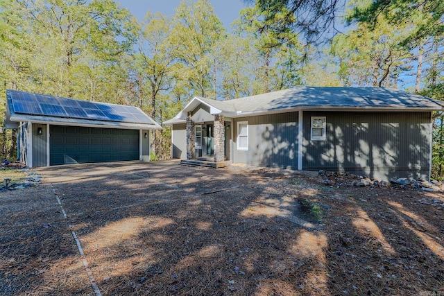 ranch-style home with solar panels and a garage