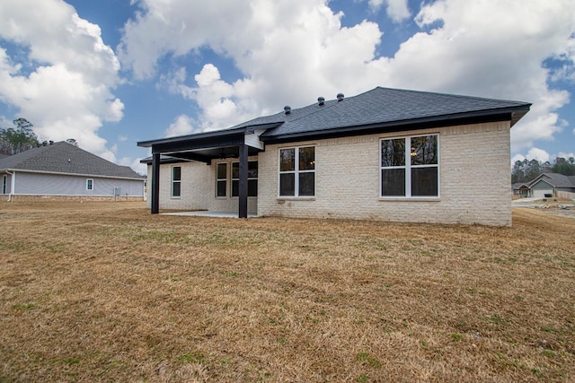 back of property with a yard and a patio