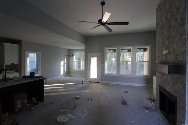 living room featuring a large fireplace and ceiling fan