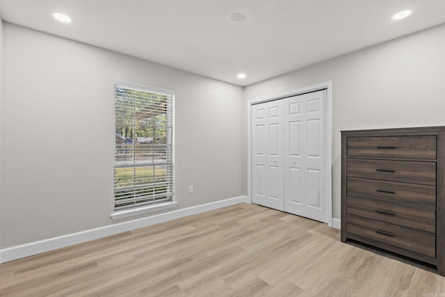 unfurnished bedroom featuring light hardwood / wood-style floors and a closet