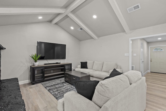 living room with vaulted ceiling with beams and light wood-type flooring