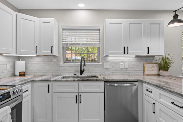 kitchen featuring white cabinets, decorative backsplash, sink, and appliances with stainless steel finishes