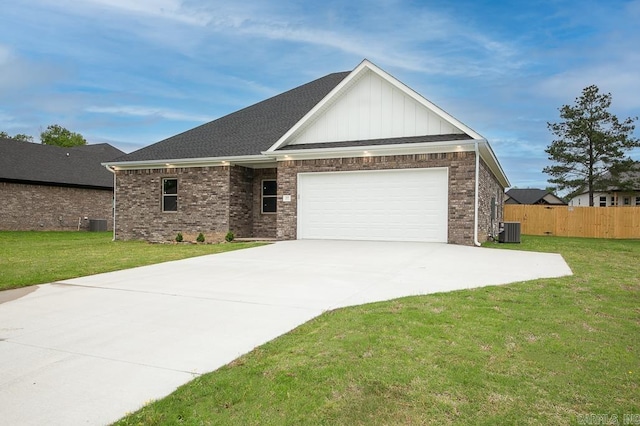 view of front of house with a garage, central air condition unit, and a front yard