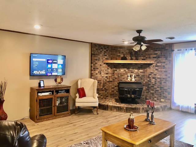 2509 Cherry St, Corning, AR 72422 - living room with a wood stove, wood finished floors, a ceiling fan, and ornamental molding