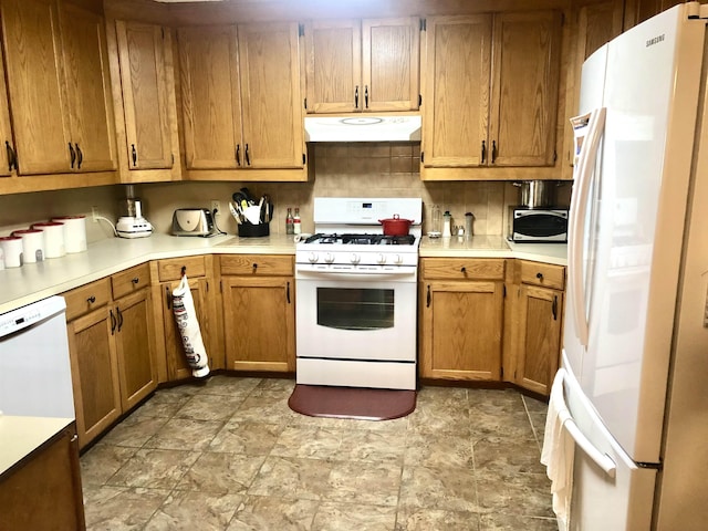 2509 Cherry St, Corning, AR 72422 - kitchen featuring white appliances, under cabinet range hood, light countertops, stone finish floors, and tasteful backsplash